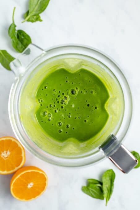 Overhead view of a blended vegan green smoothie inside the blender.