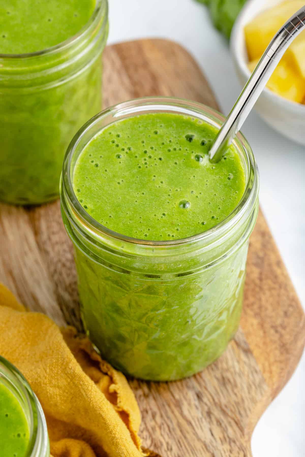Green Smoothie in glass with a straw sticking out