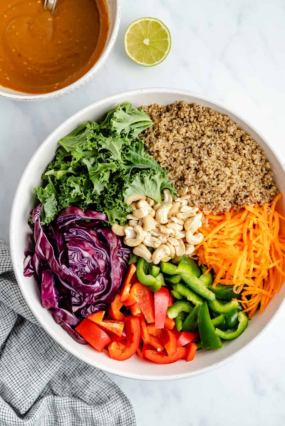 salad ingredients mixed together with dressing beside it