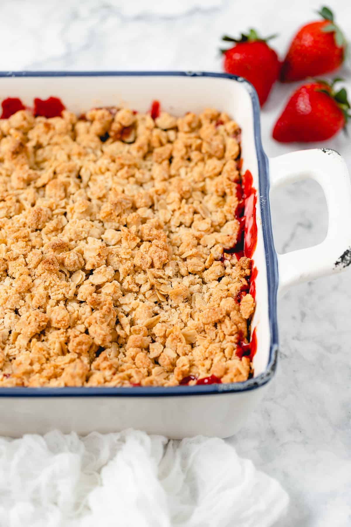 finished strawberry crisp with red sauce oozing under golden brown crisp topping