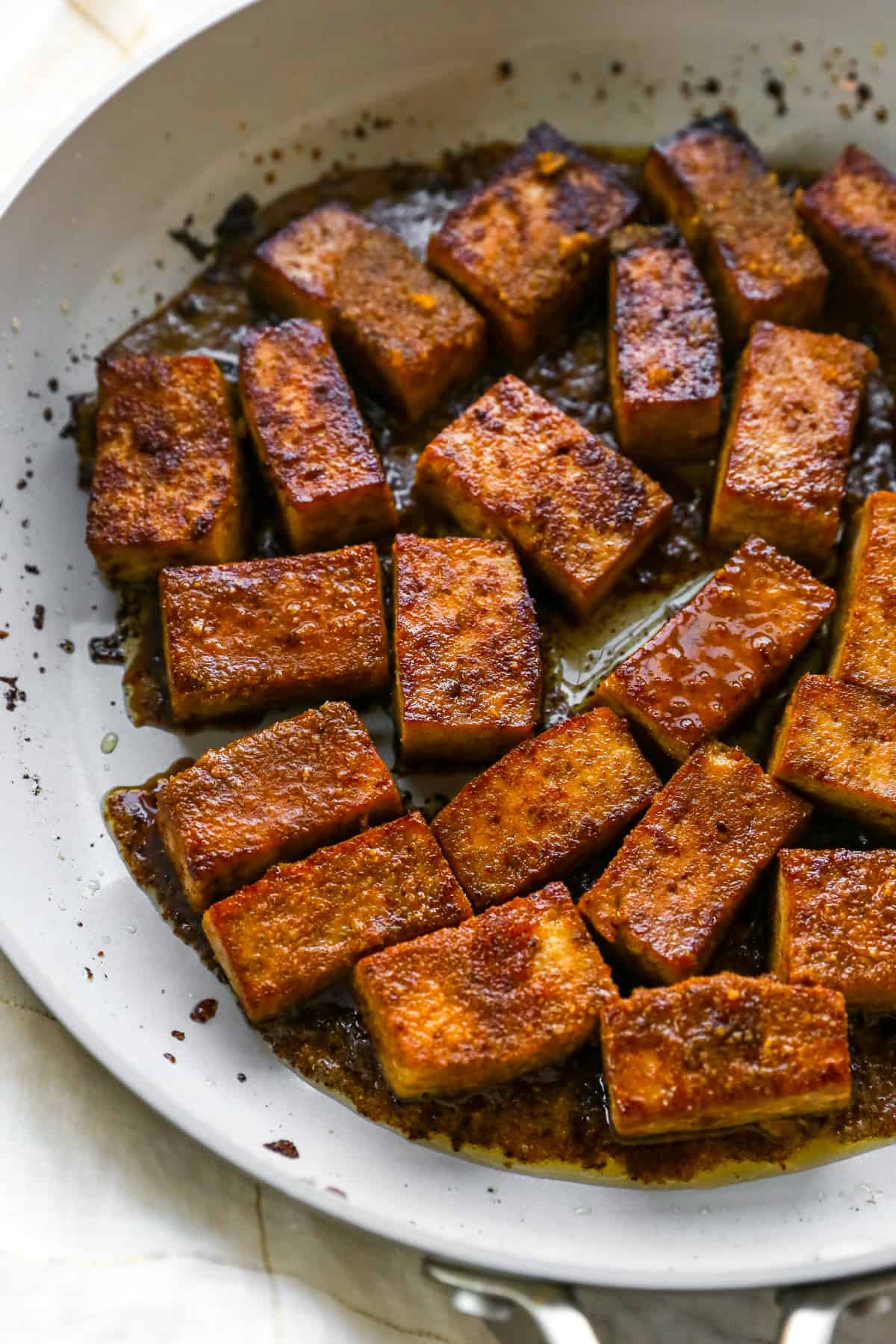 marinated and cooked tofu with leftover sauce in pan