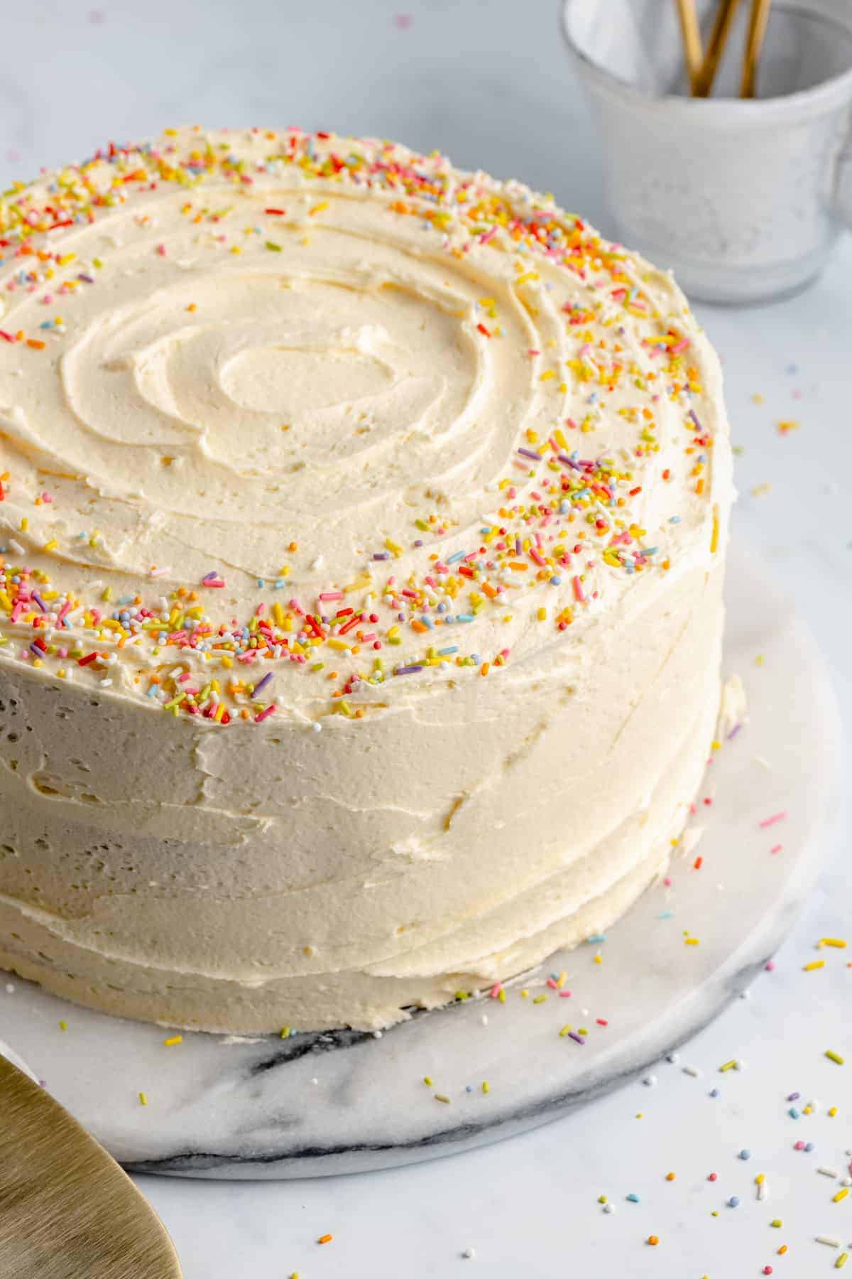 vegan vanilla cake on a stand with vegan buttercream frosting