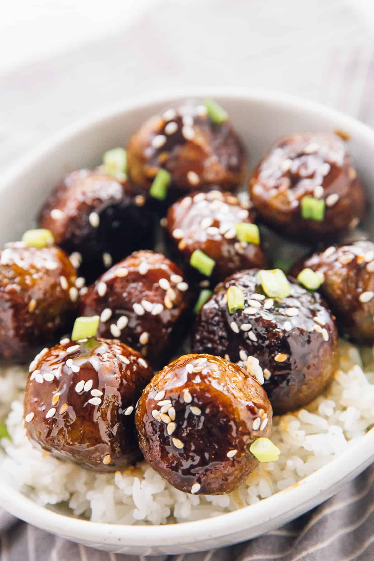 Close-up shot of veggie meatballs covered in sauce on a bed of white rice