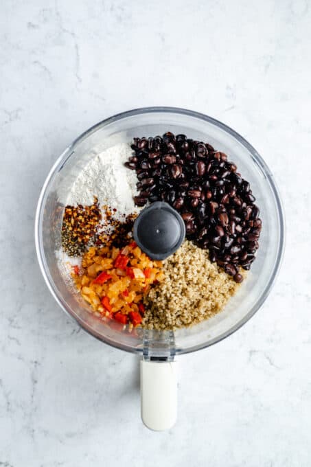 Black beans and quinoa with seasoning in a food processor.