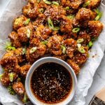 plate of cauliflower wings in a tray with sauce in a small bowl beside it