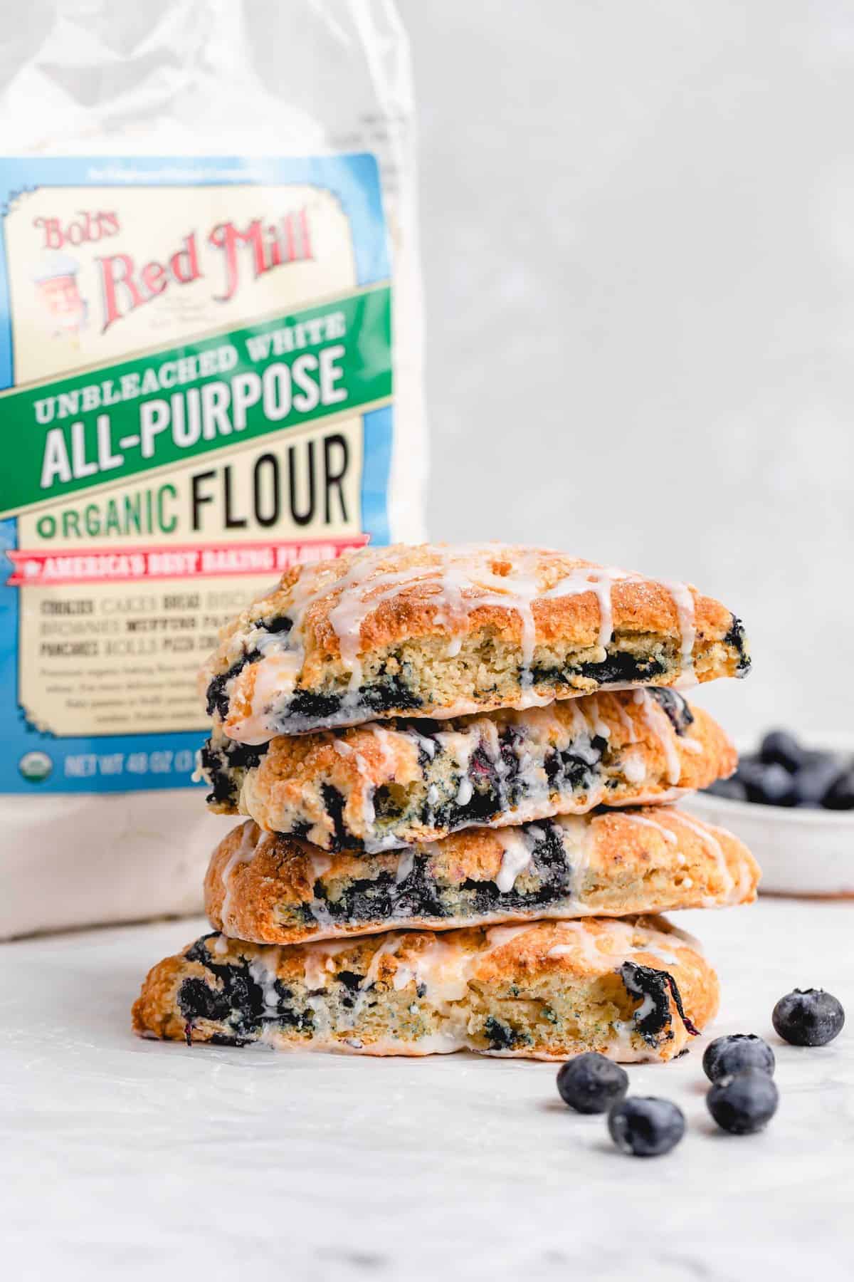 four stacked blueberry scones with a bag of Bob's Red Mill flour behind it