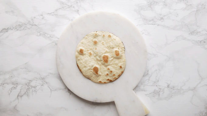 A tortilla on a cutting board. - 6