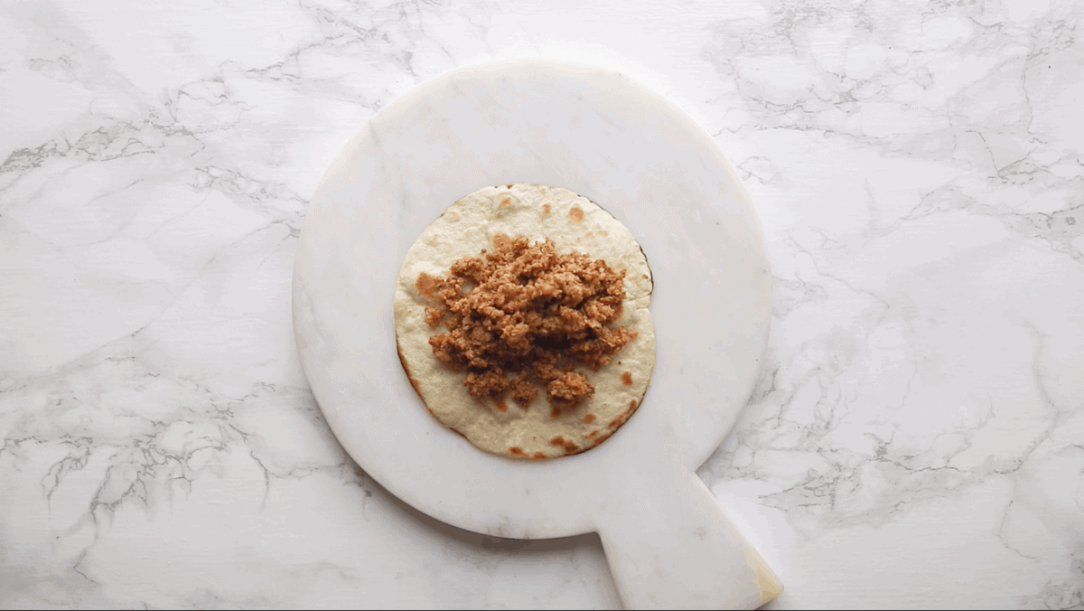 Tortilla with ground walnut meat on it.