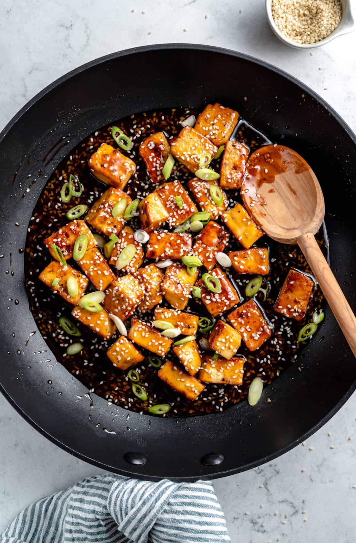 Tofu cooking with chopped scallions.