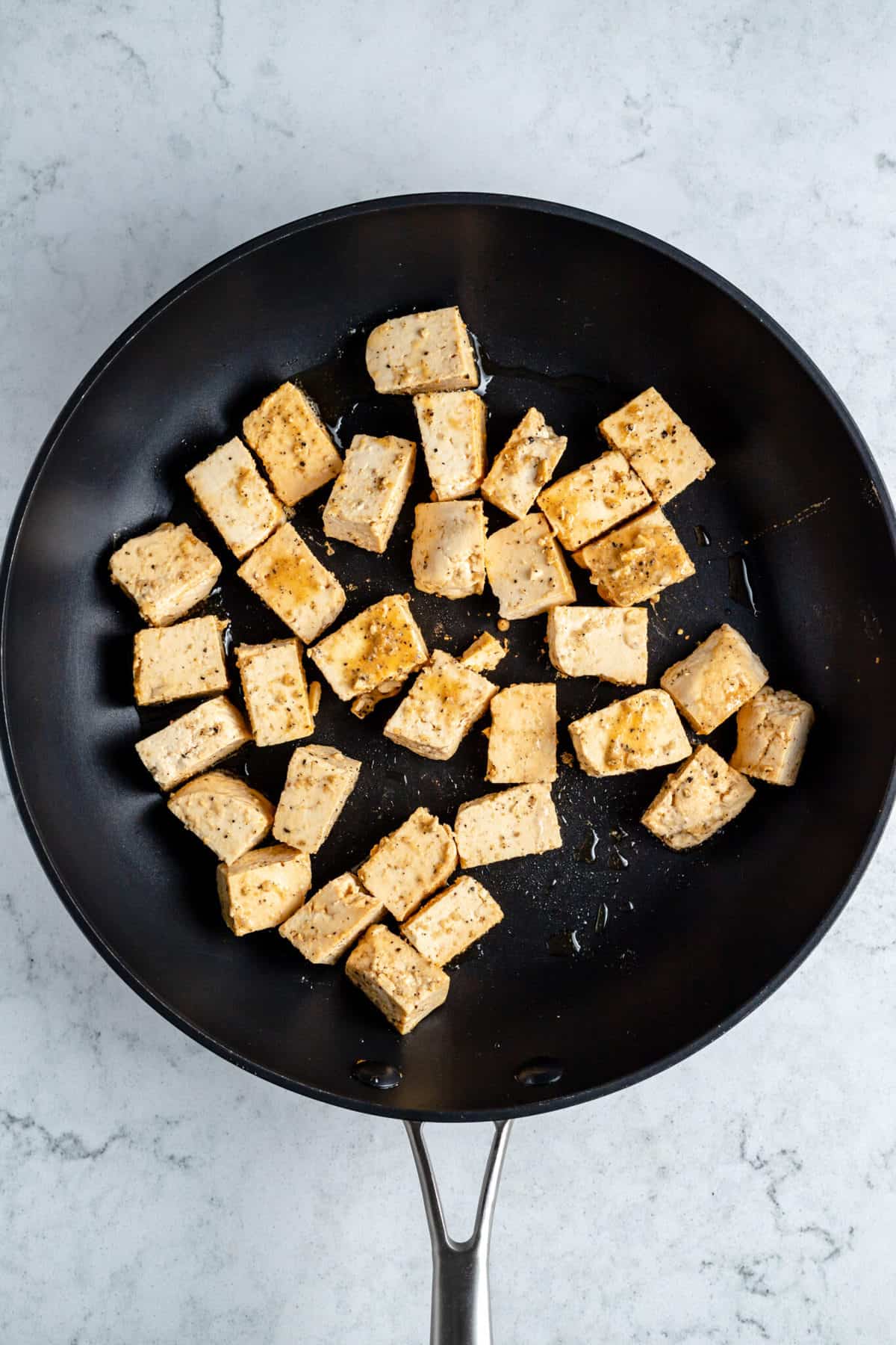 Tofu cubes in a frying pan.