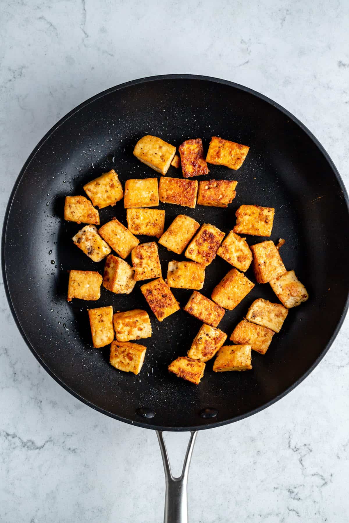 Crispy tofu in a frying pan.