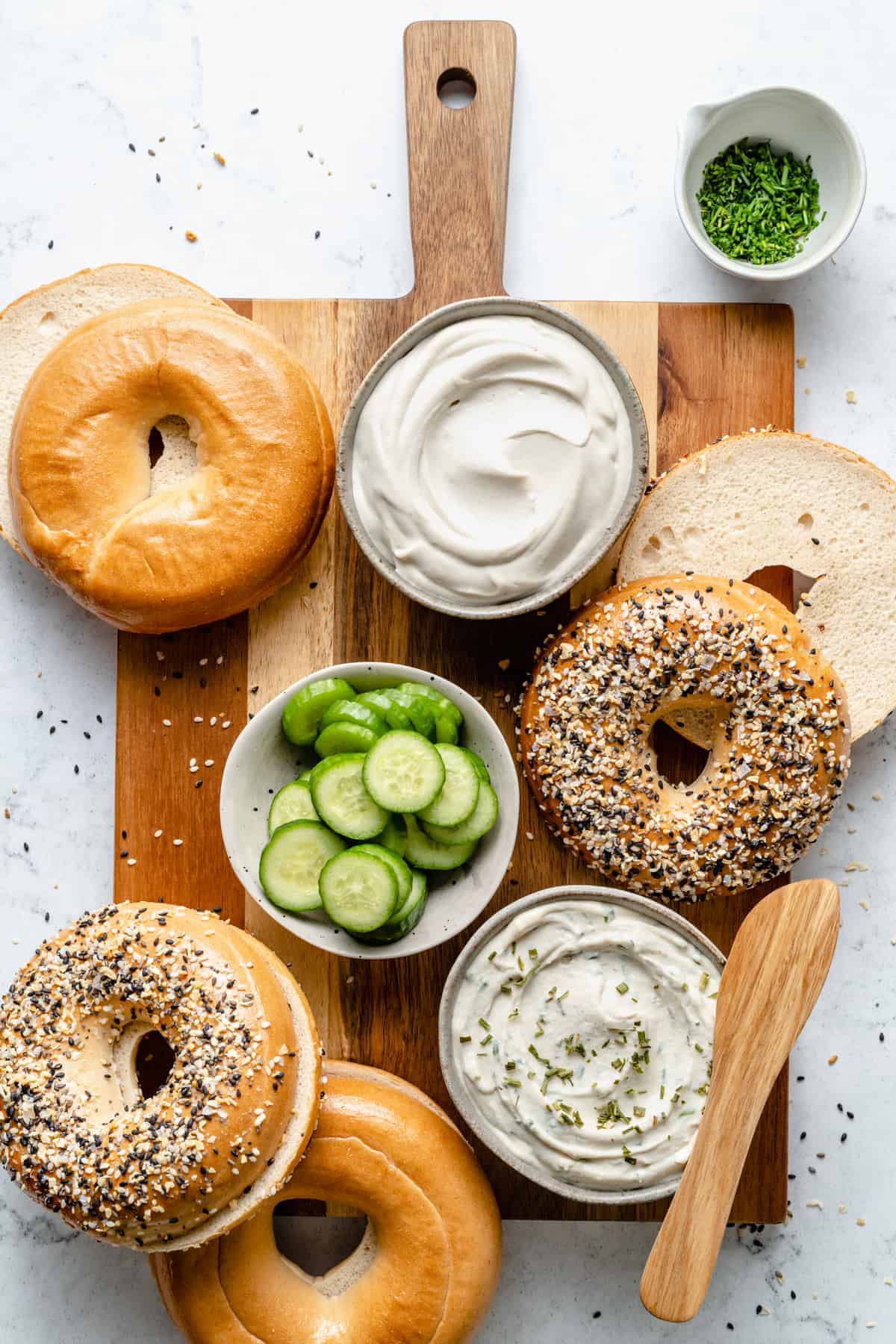 Bagels with cream cheese and cucumber slices.