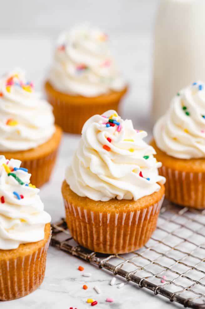 Vegan vanilla cupcakes with rainbow sprinkles.