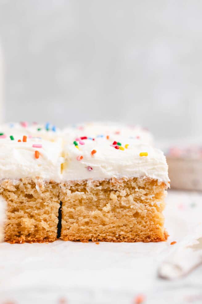 Frosted cake squares with rainbow sprinkles.