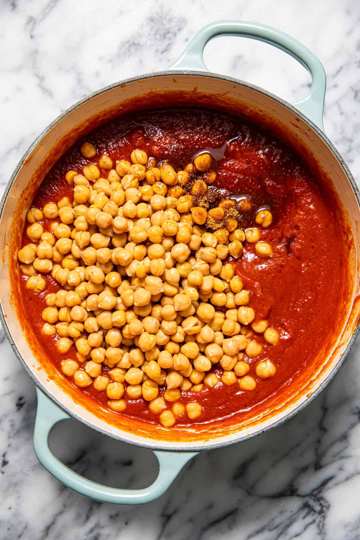 Chickpeas in a pan of tomato sauce.