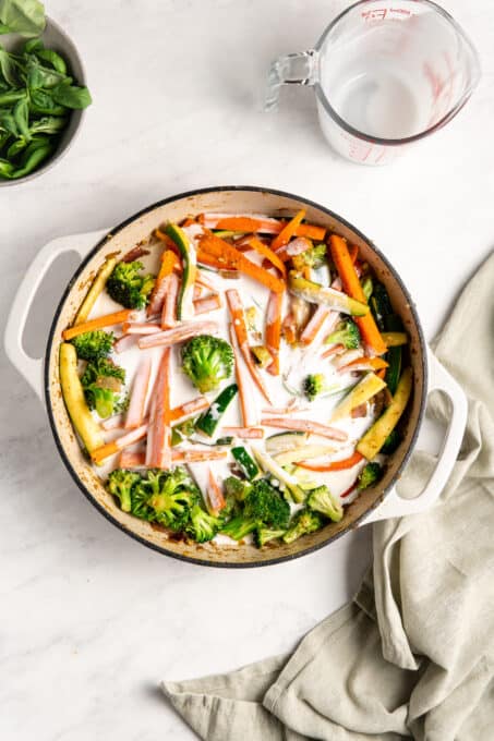 Cooked vegetables in a pan with coconut milk.