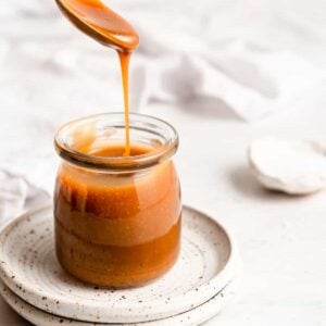 Homemade caramel sauce in a glass jar.