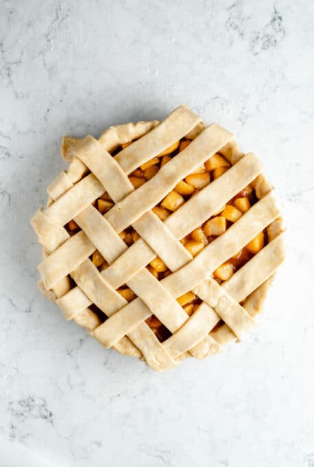 Pie crust forming a lattice over cooked apples.