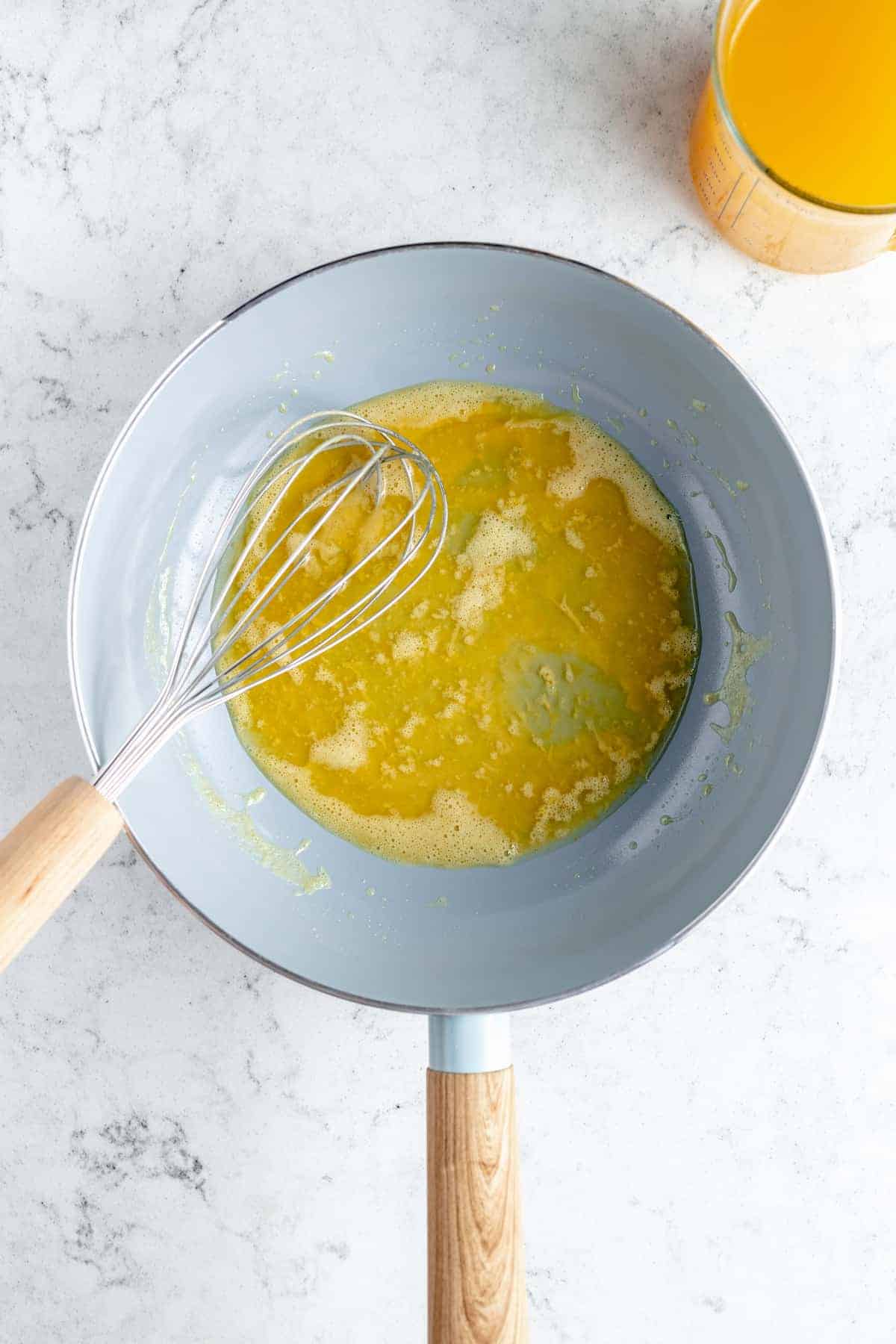 Overhead shot of melted butter in saucepan with whisk