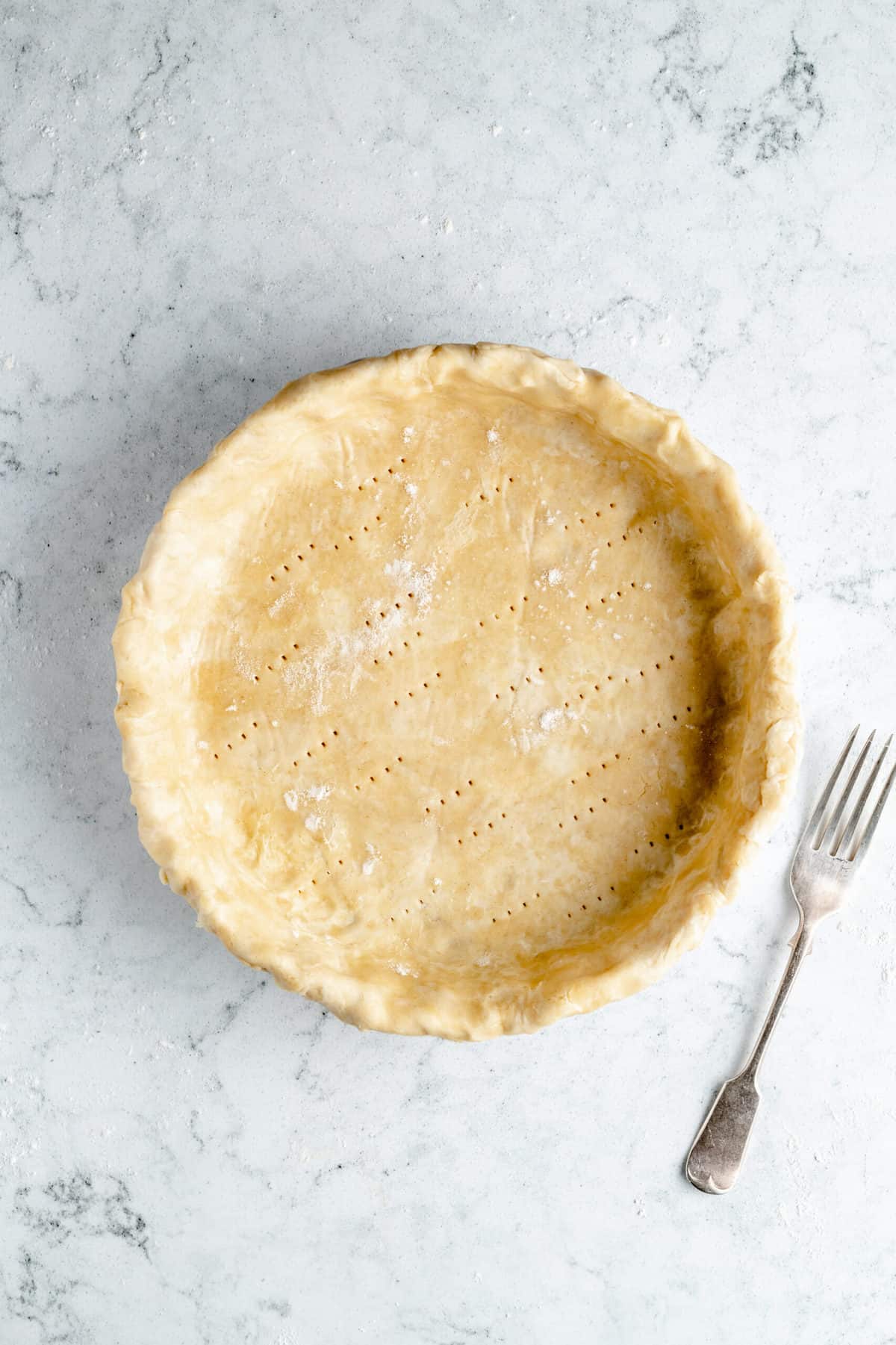 Vegan pie crust with fork indentations.