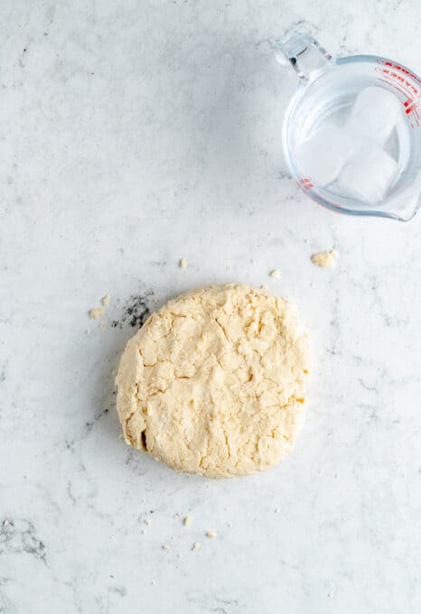 A disk of pie dough on a counter.