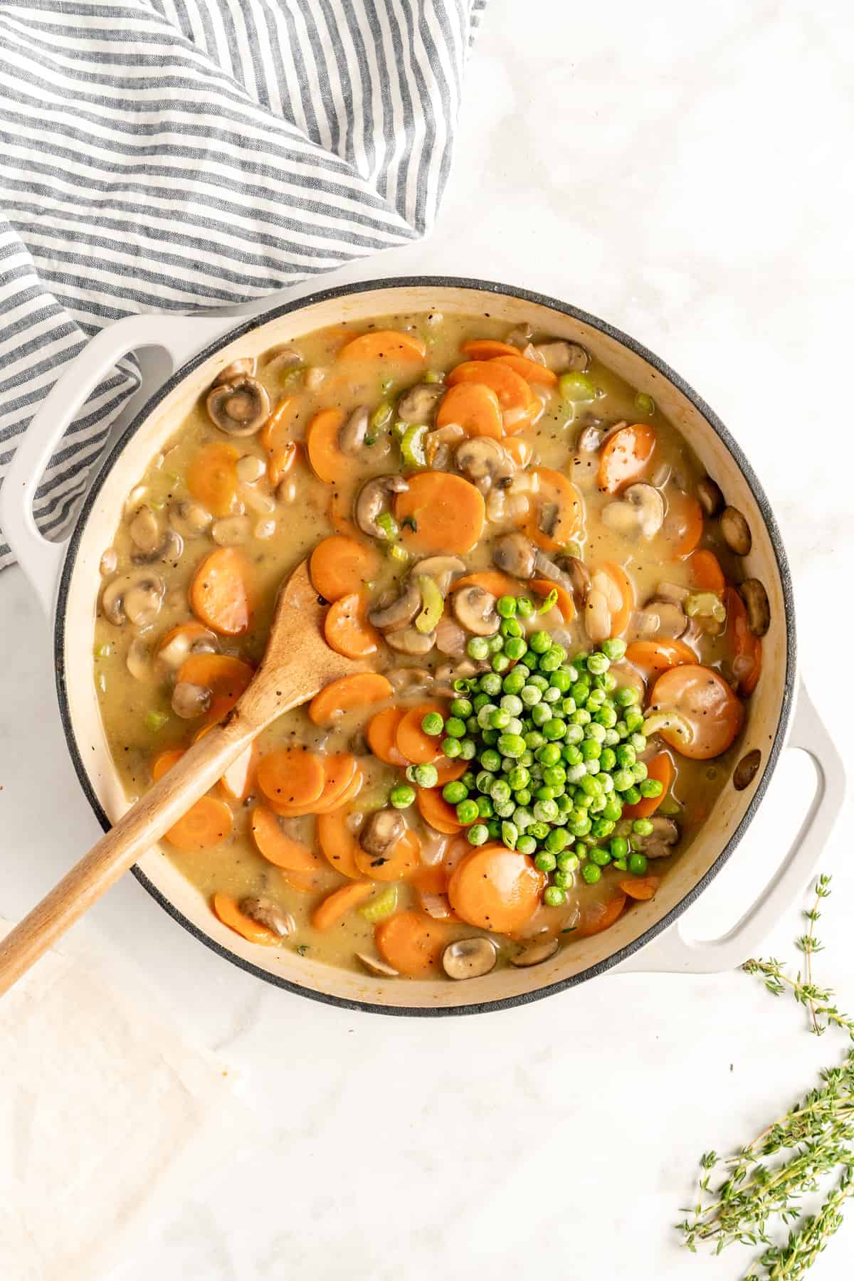 Peas added to a dutch oven with pot pie filling