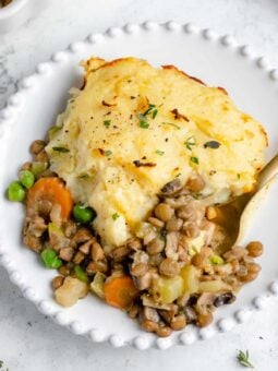Serving of Vegan Shepherd's Pie on white plate with fork