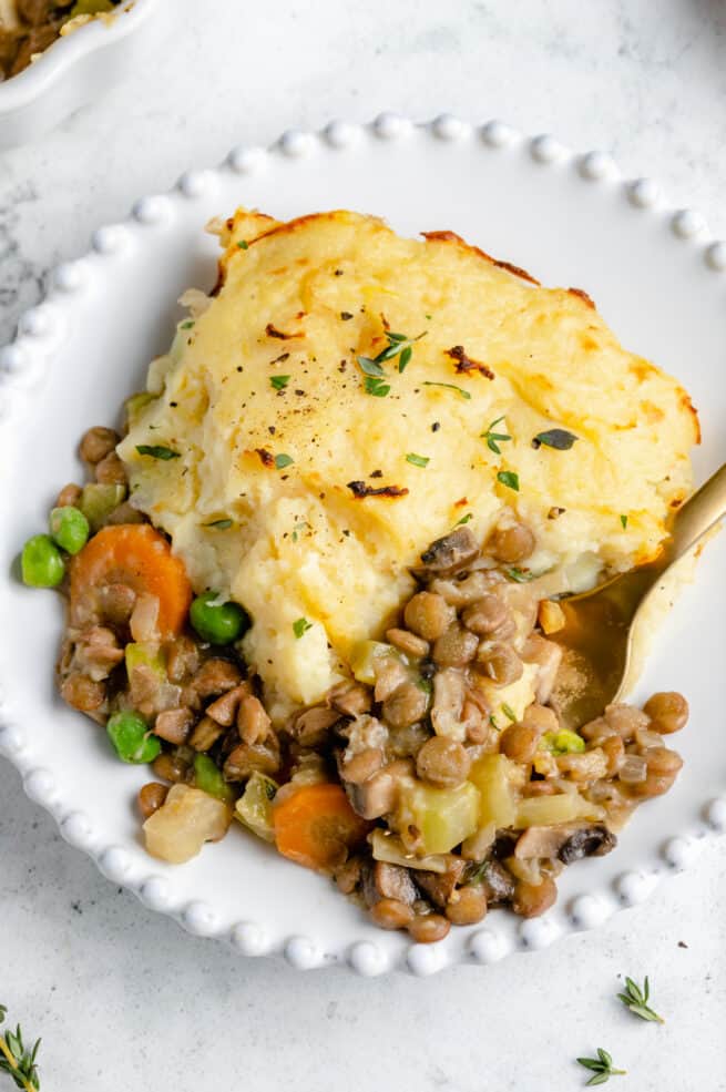 Serving of Vegan Shepherd's Pie on white plate with fork
