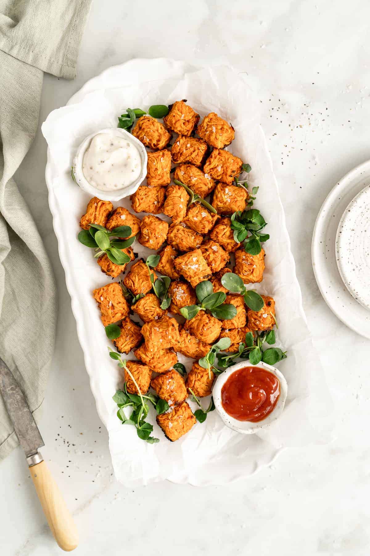 Overhead view of sweet potato tots on serving platter with dipping sauces