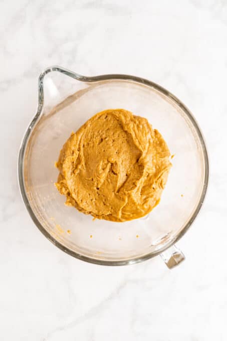 Overhead view of pumpkin bread batter in glass mixing bowl