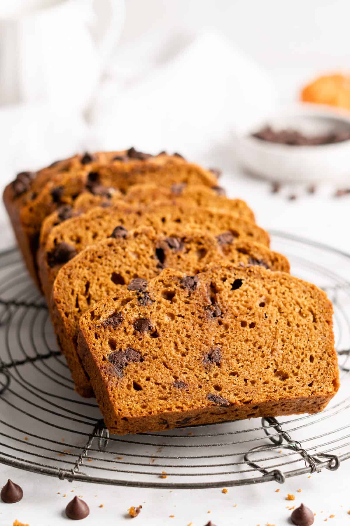 Slices of chocolate chip pumpkin bread on round wire cooling rack