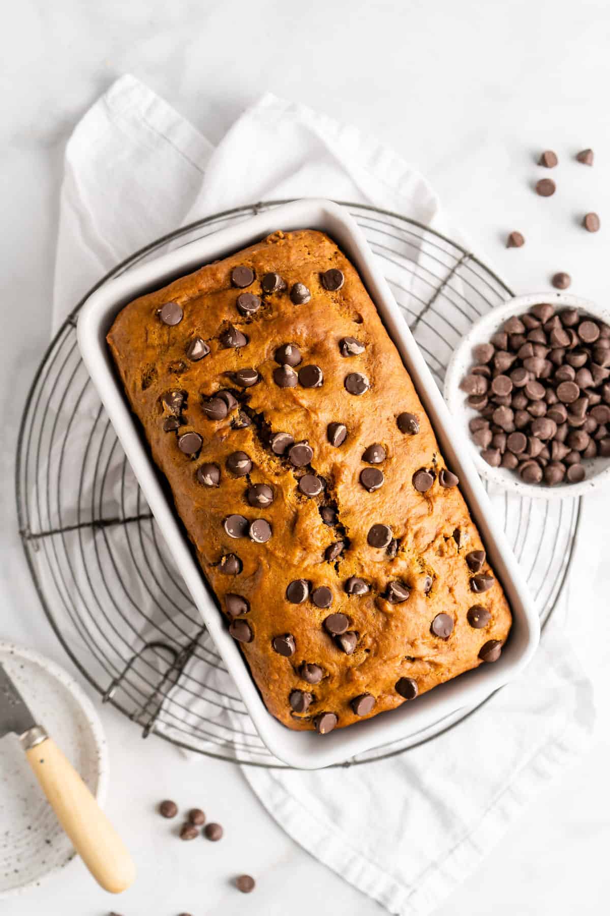 Chocolate chip pumpkin bread in bread pan on cooling rack