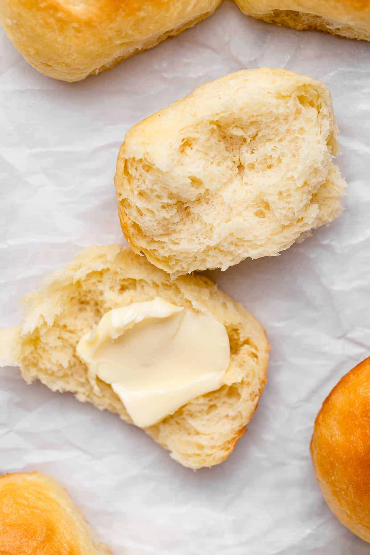 dinner roll torn in half with a pat of vegan butter on it