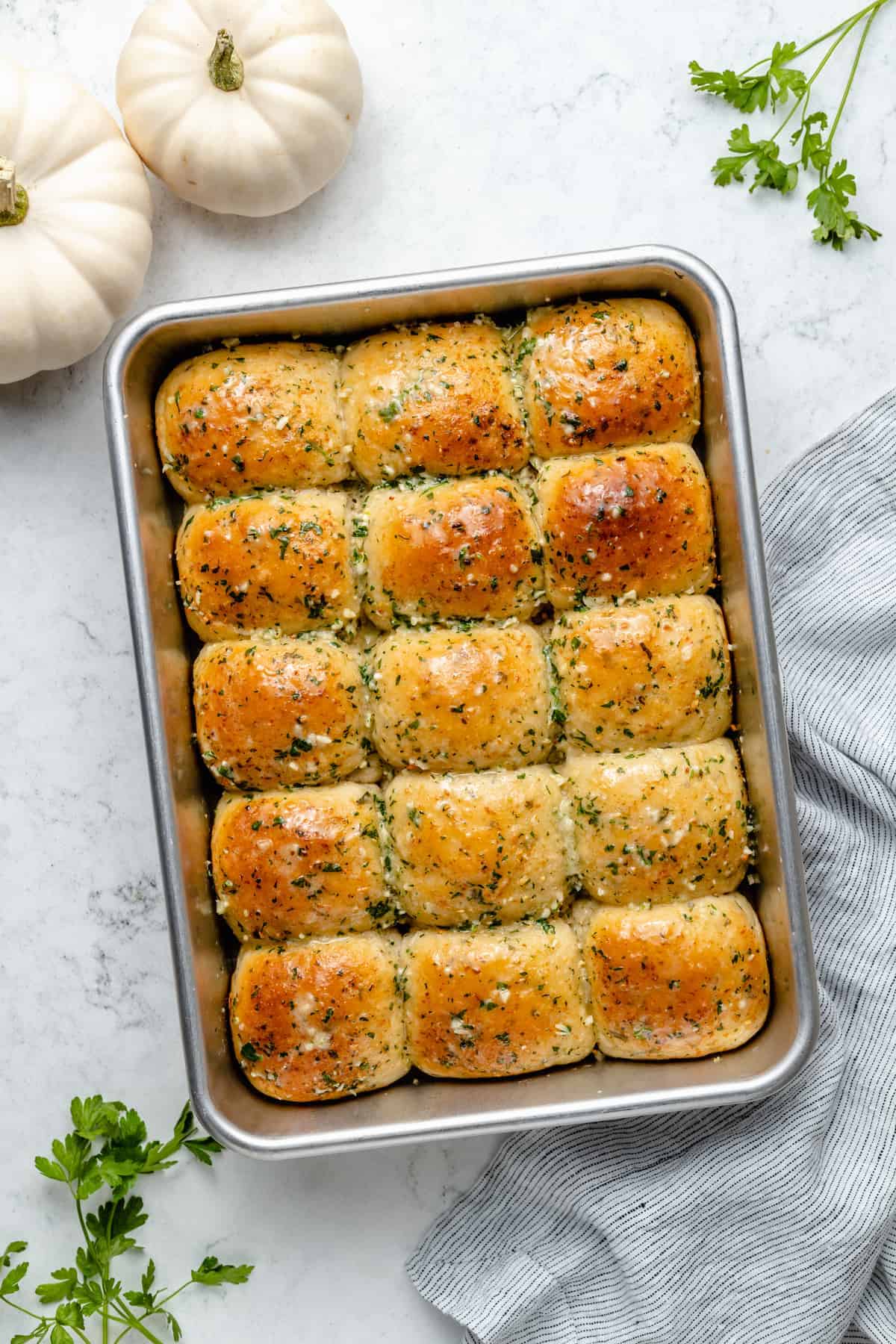 Overhead view of garlic dinner rolls in metal baking pan