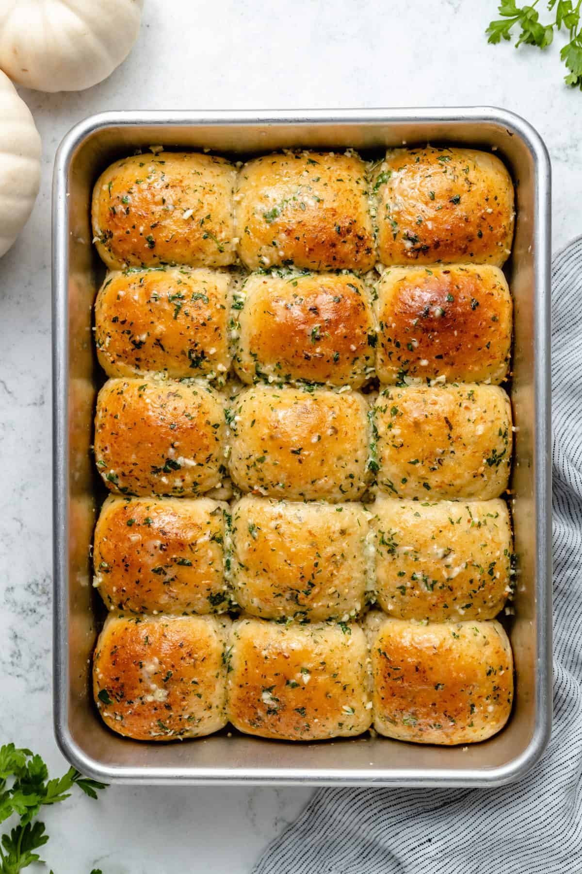 Overhead view of vegan garlic parmesan dinner rolls in metal baking pan