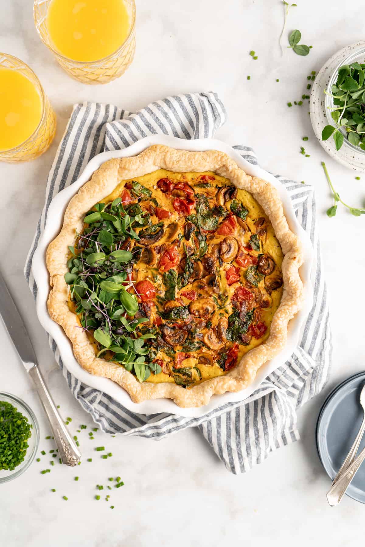 Overhead view of vegan vegetable quiche topped with greens
