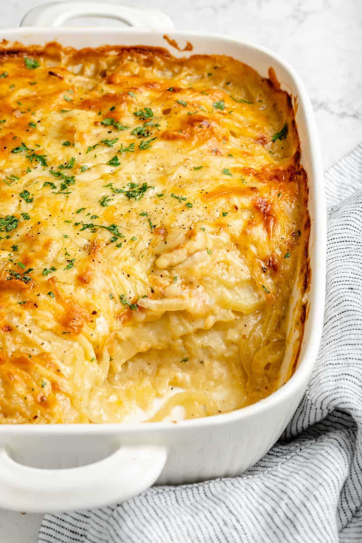 Vegan scalloped potatoes in white baking dish with serving removed