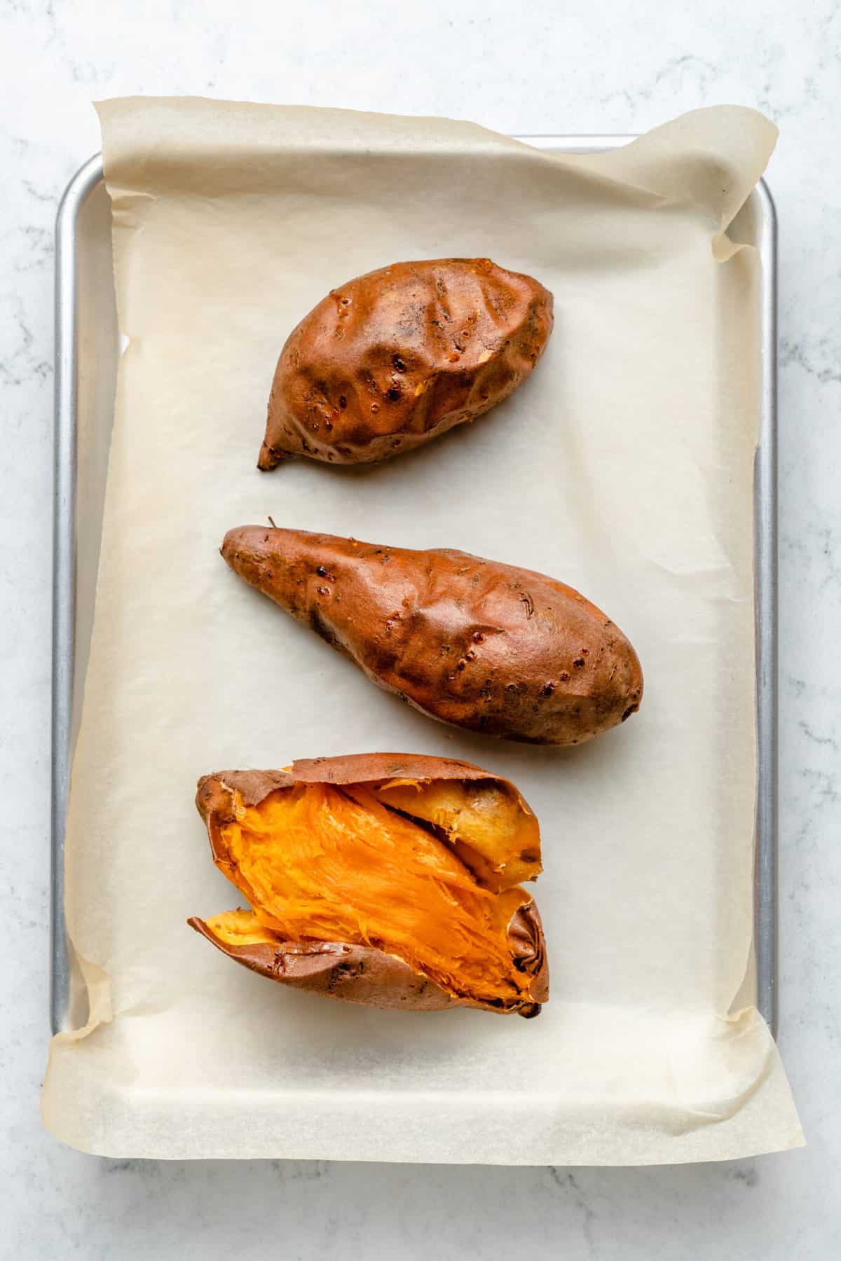 baked sweet potatoes with skin torn open
