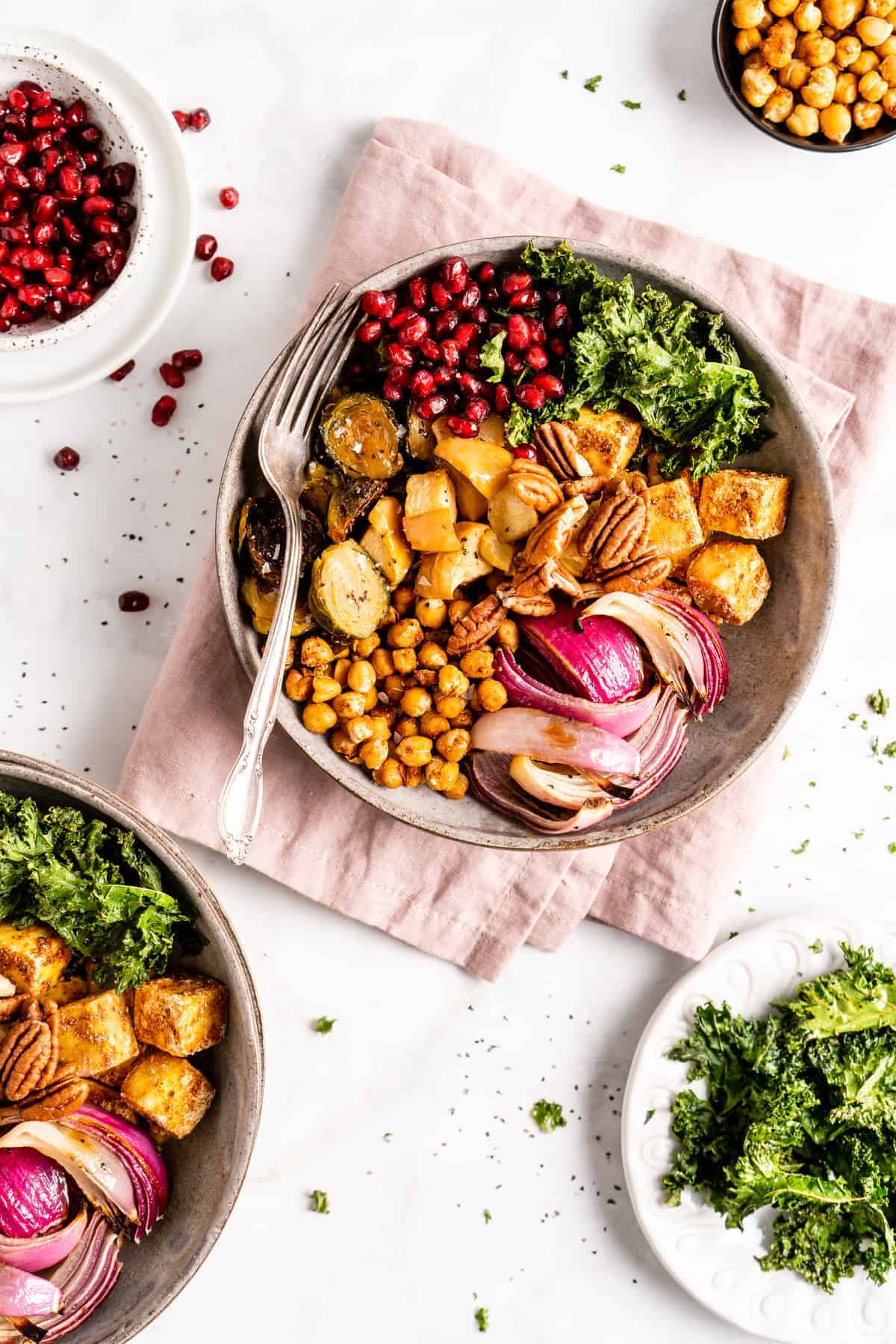 Overhead view of a vegan Buddha bowl with a fork on pink cloth napkin.