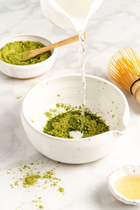 Pouring hot water into bowl of matcha powder