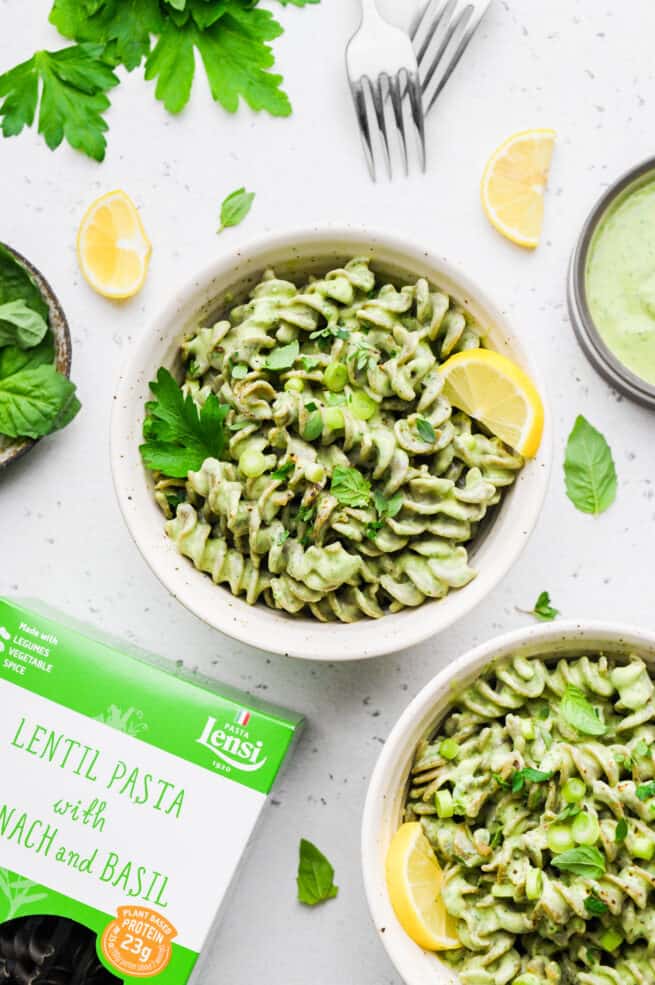 green goddess pasta in two bowls with box of pasta in the corner