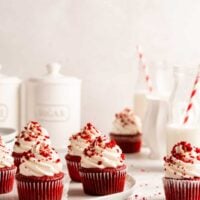 Vegan red velvet cupcakes with cream cheese frosting and cake crumbs on plate