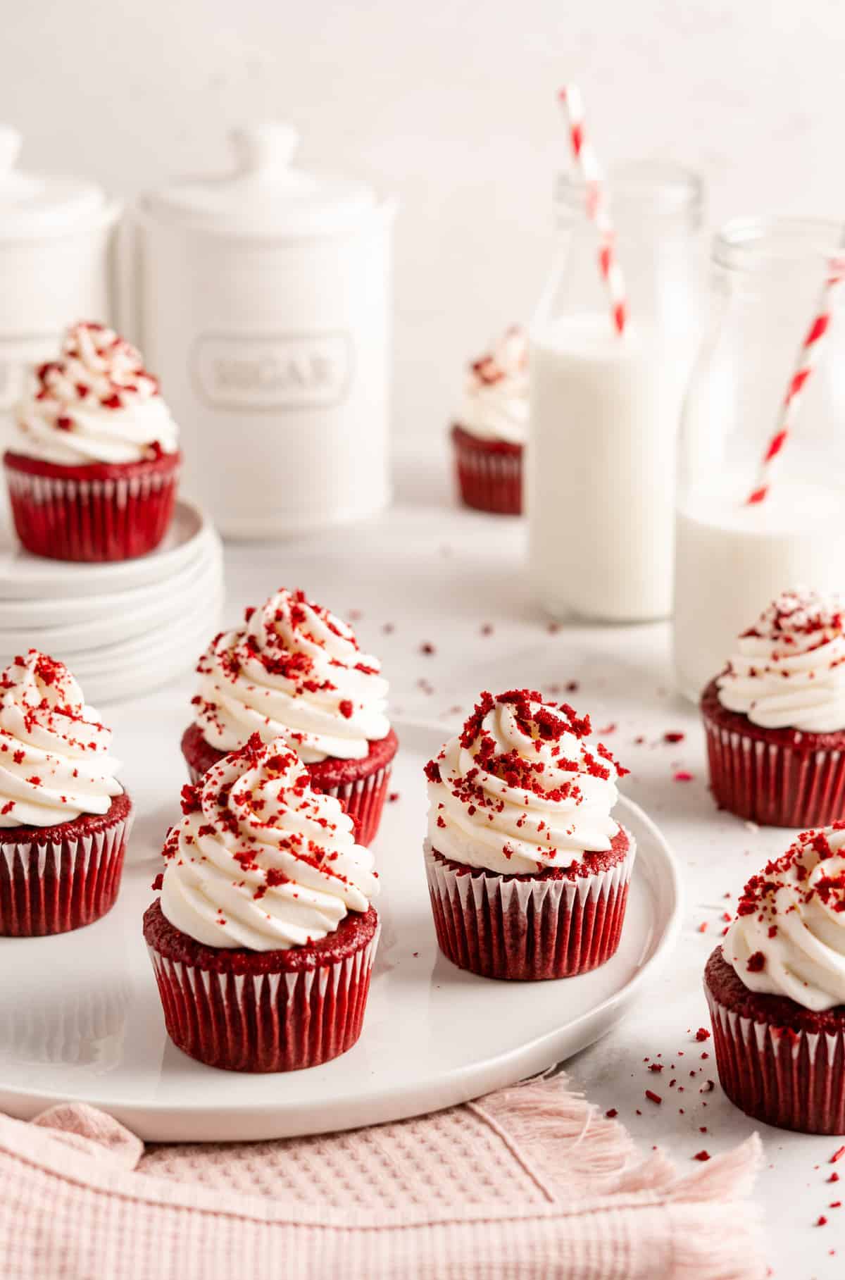 Vegan red velvet cupcakes decorated with cream cheese frosting and cake crumbs