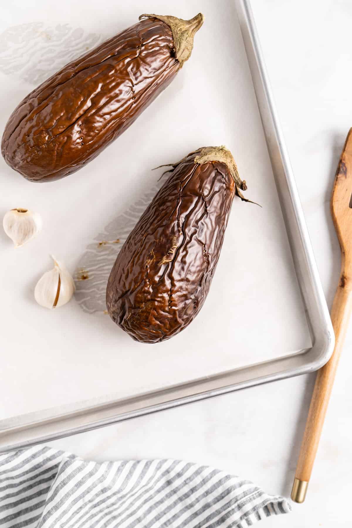 Roasted eggplants and garlic on baking sheet