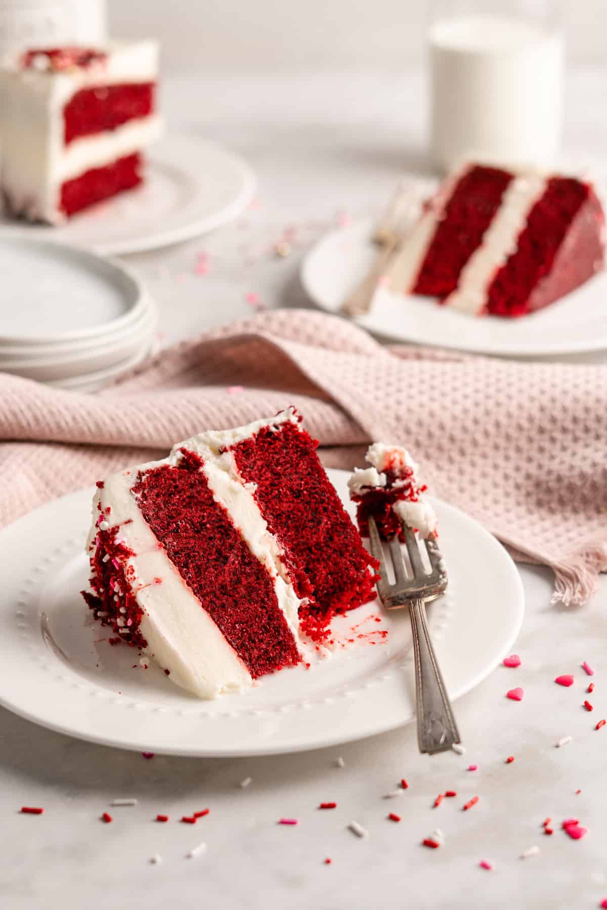 Slices of vegan red velvet cake on dessert plates