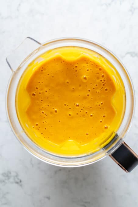 Overhead view of roasted carrot soup in blender