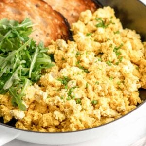 Tofu scrambled eggs with browned toast in a pan.