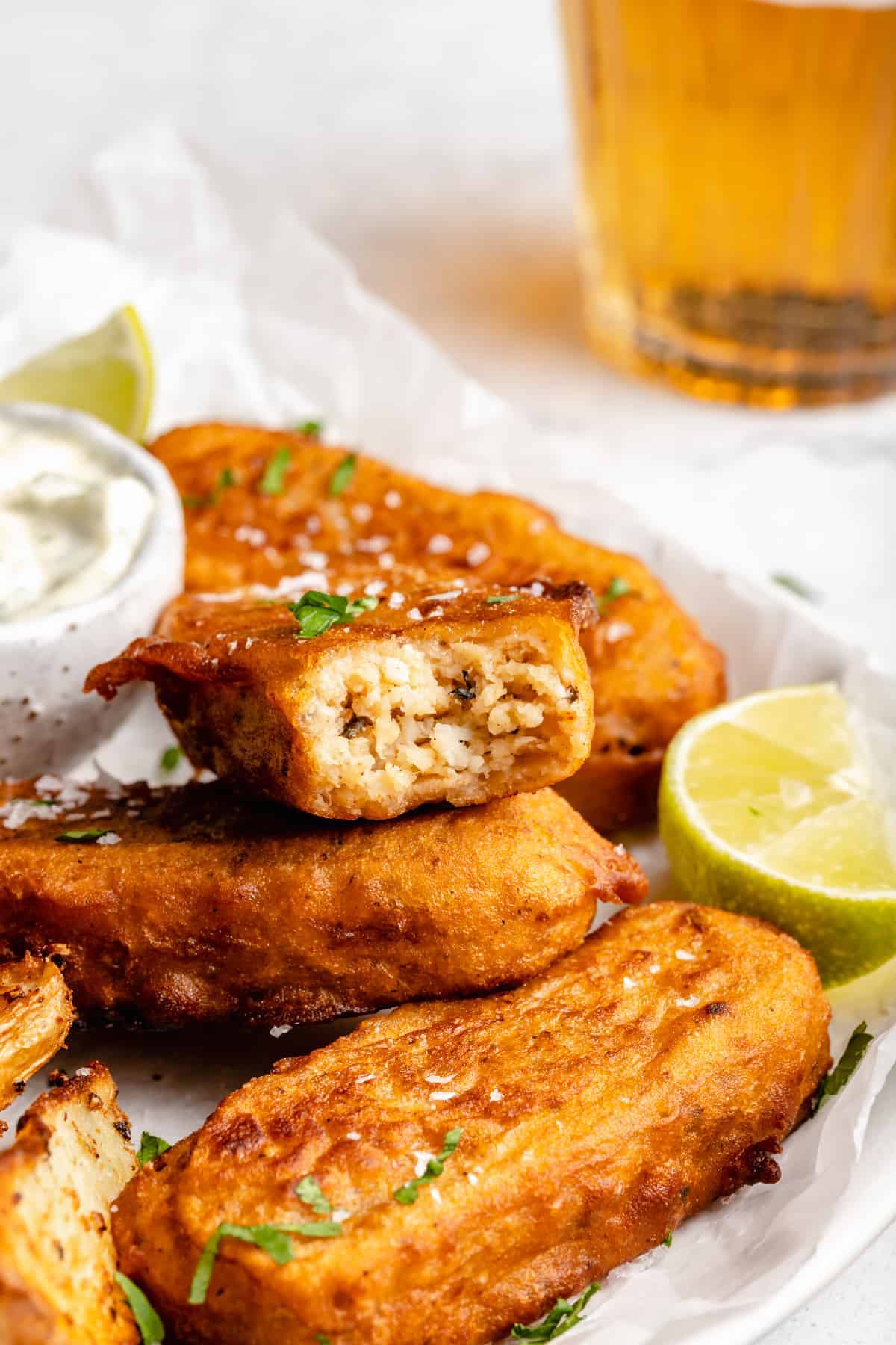 Closeup of vegan fish stick with bite removed, showing flaky interior