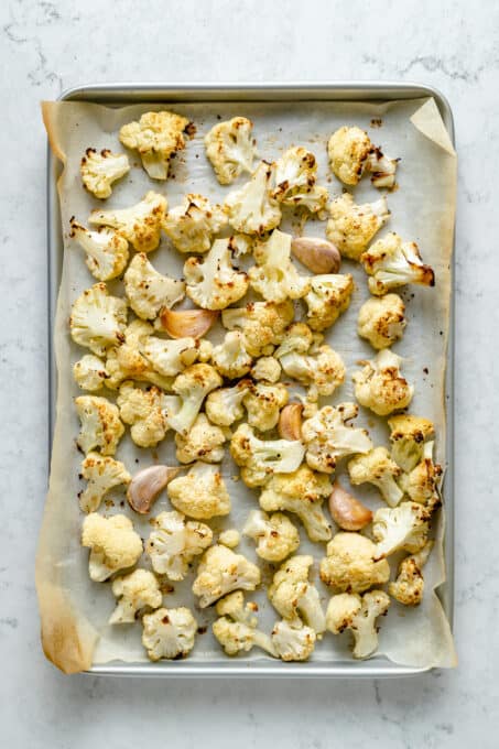 Roasted cauliflower on parchment-lined baking sheet