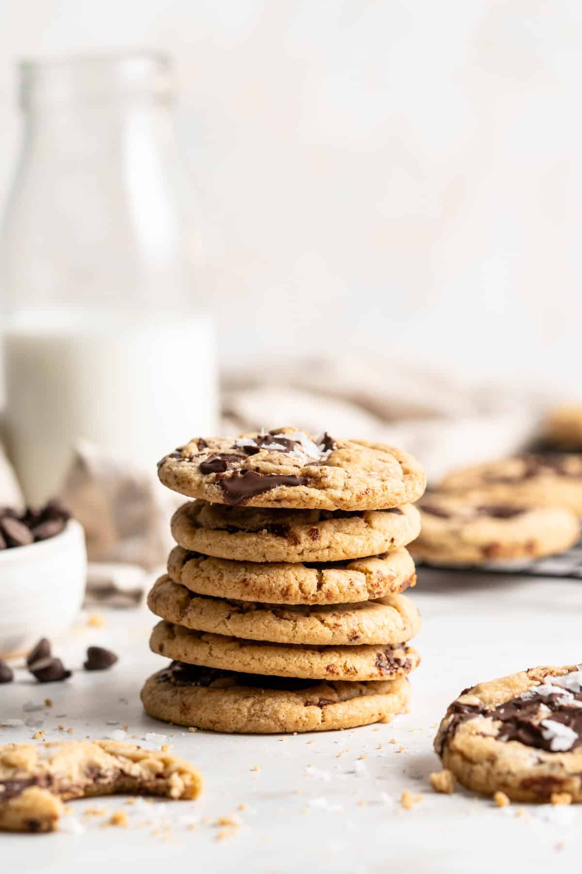 Stack of vegan chocolate chip cookies with pitcher of milk in background